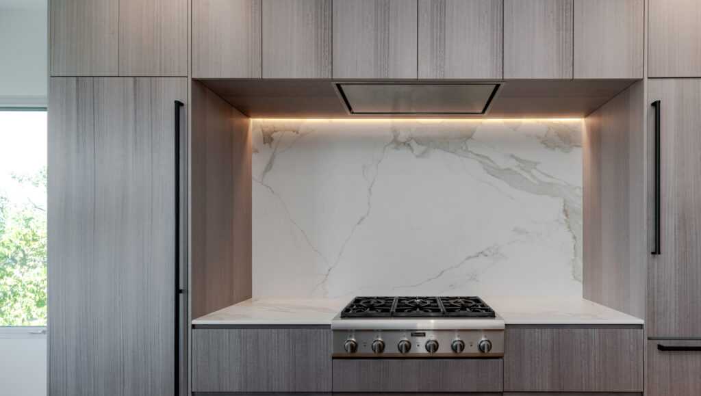 Flush-mounted kitchen hood that blends into surrounding cabinets
